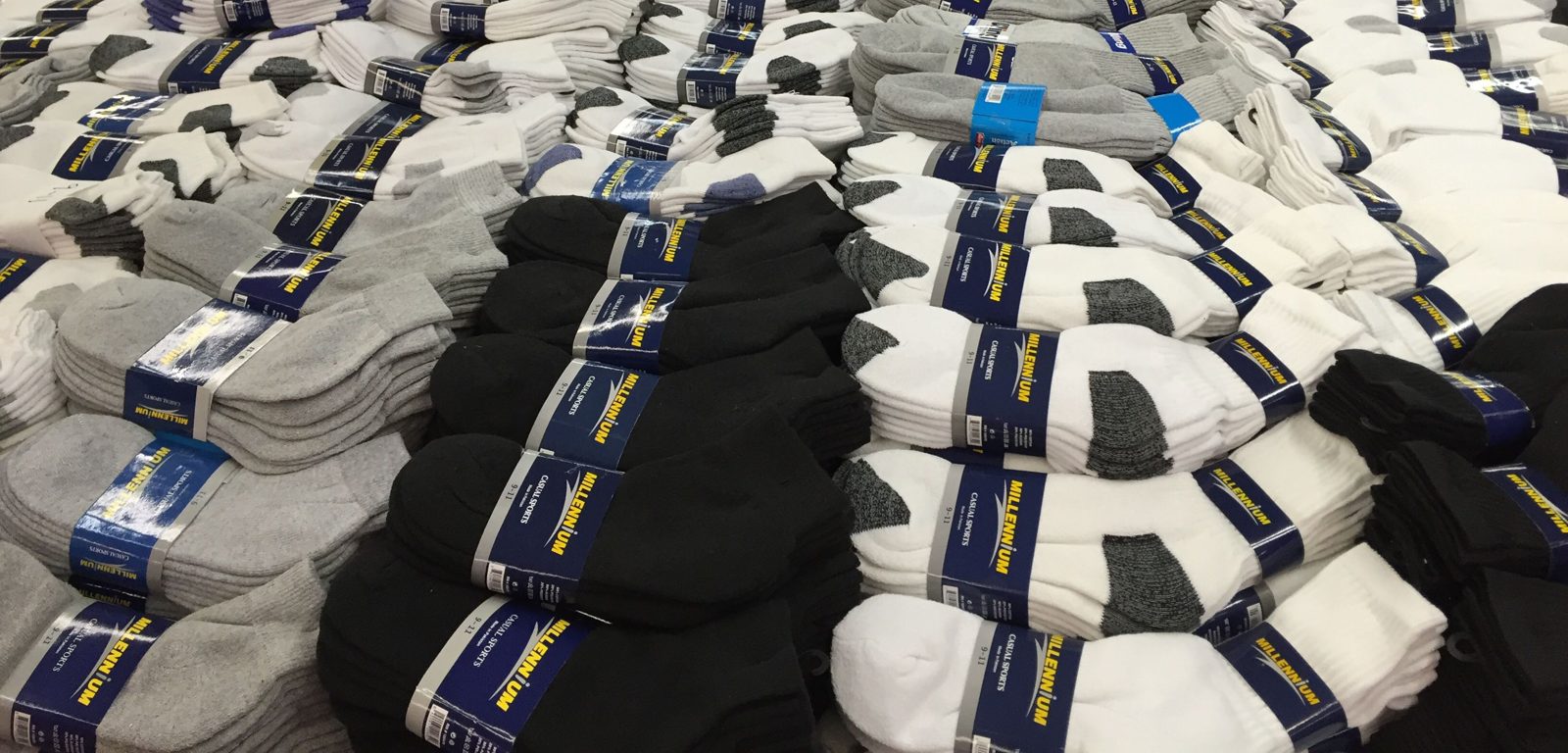 Tables piled with bundled white, gray and black socks